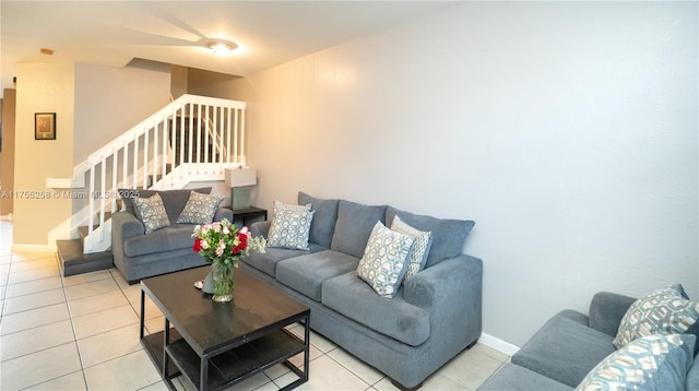 living room with light tile patterned floors, stairs, and baseboards