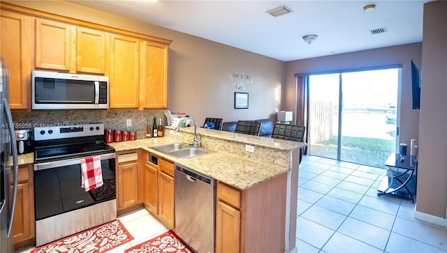 kitchen featuring light tile patterned floors, stainless steel appliances, visible vents, a sink, and a peninsula