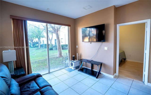 living room featuring light tile patterned floors, visible vents, and baseboards