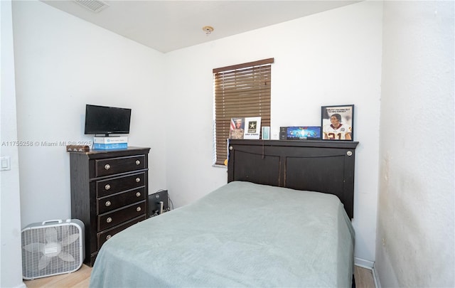 bedroom featuring visible vents and wood finished floors