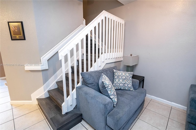 stairway with baseboards and tile patterned floors