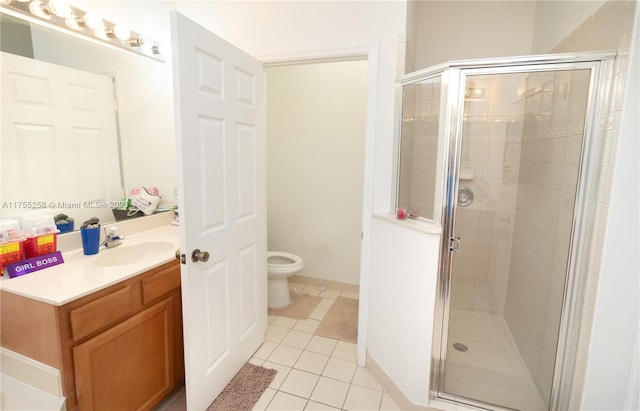 full bathroom featuring toilet, a shower stall, vanity, and tile patterned floors