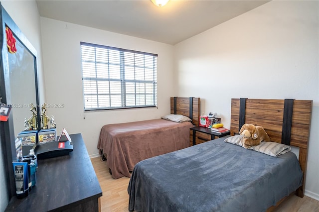 bedroom featuring light wood-type flooring and baseboards