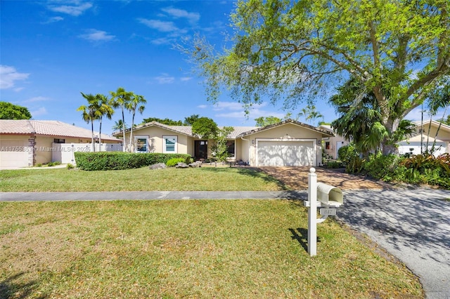 single story home featuring driveway, stucco siding, an attached garage, and a front yard