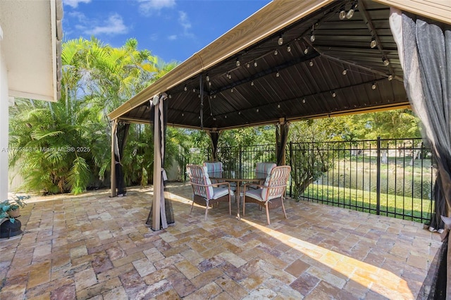 view of patio / terrace with a gazebo, outdoor dining area, and fence