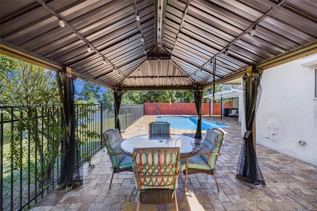 view of patio with a fenced in pool, outdoor dining area, a fenced backyard, and a gazebo