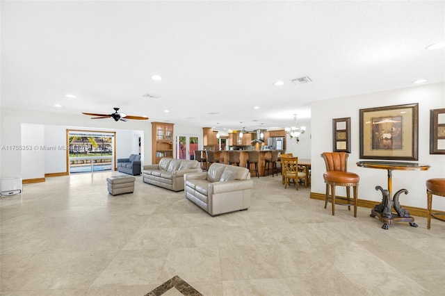 living room featuring baseboards, ceiling fan with notable chandelier, visible vents, and recessed lighting