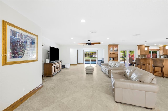 living area featuring recessed lighting, ceiling fan, and baseboards