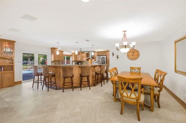 dining room featuring a chandelier and baseboards