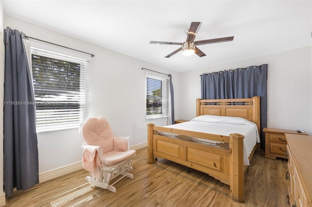 bedroom featuring light wood-style flooring, baseboards, and ceiling fan