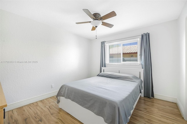 bedroom with wood finished floors, a ceiling fan, and baseboards