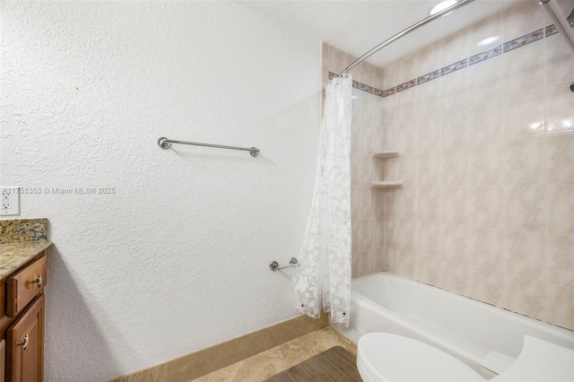 full bathroom with shower / tub combo, a textured wall, vanity, and toilet