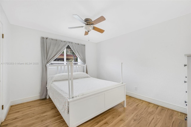 unfurnished bedroom with light wood finished floors, a ceiling fan, and baseboards
