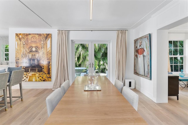 dining room with light wood-type flooring, baseboards, and french doors