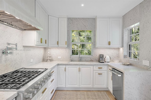 kitchen with stainless steel appliances, premium range hood, decorative backsplash, and white cabinets