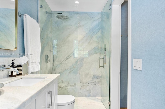 bathroom with vanity, toilet, and a marble finish shower