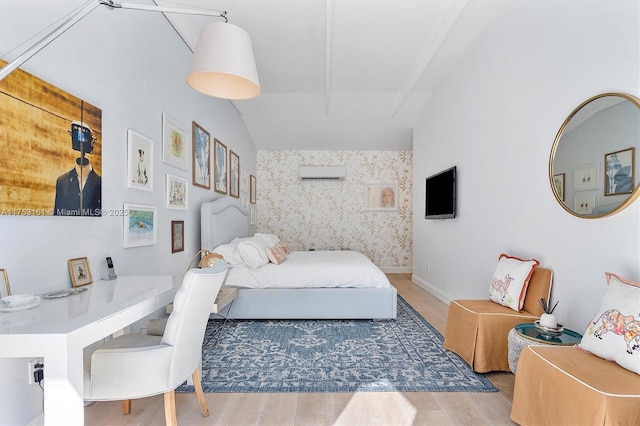 bedroom with a wall unit AC, wood finished floors, baseboards, and vaulted ceiling