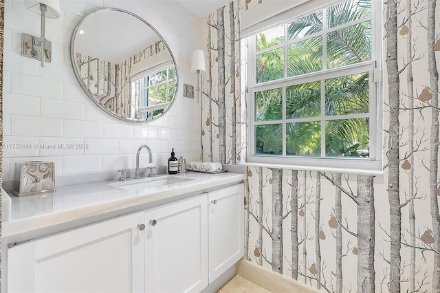 bathroom with a healthy amount of sunlight, vanity, and tile walls