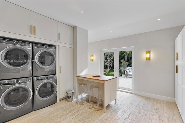 laundry room featuring light wood-type flooring, cabinet space, stacked washer and dryer, and independent washer and dryer