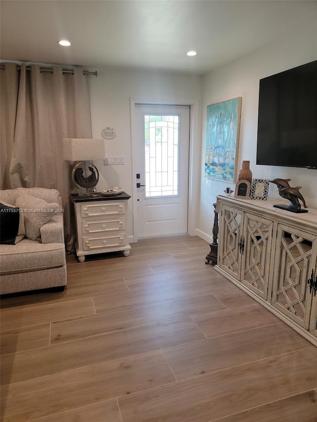 doorway featuring light wood-style flooring, baseboards, and recessed lighting