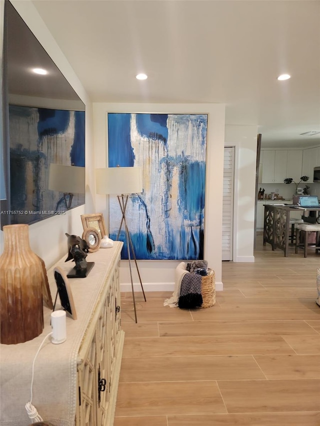 interior space with baseboards, light wood-type flooring, and recessed lighting