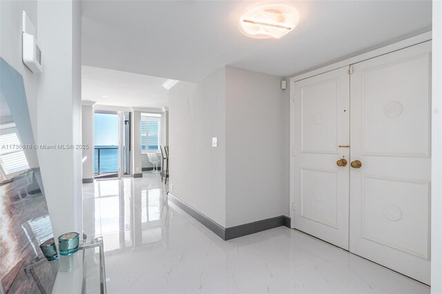 foyer entrance featuring baseboards and marble finish floor