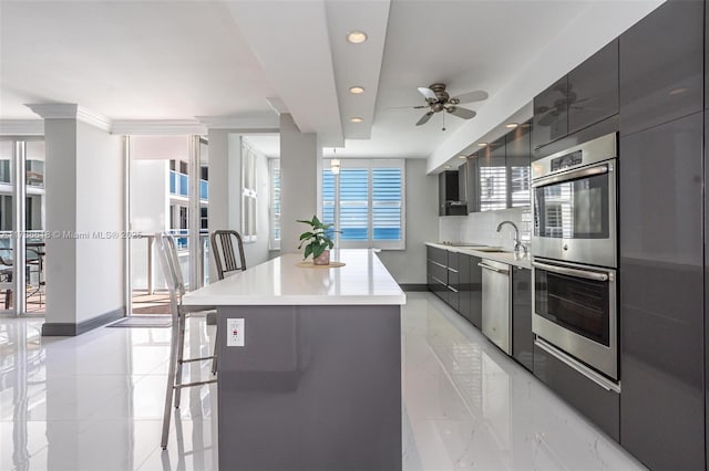 kitchen with modern cabinets, ceiling fan, stainless steel appliances, a kitchen island, and recessed lighting