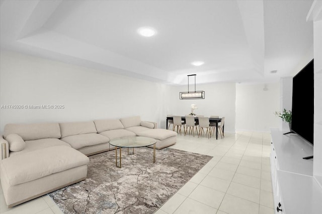 living room featuring light tile patterned floors and a raised ceiling