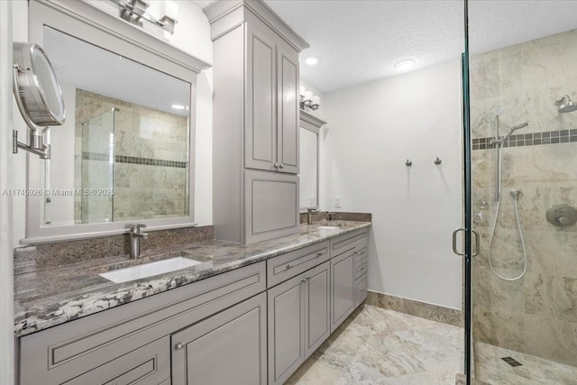 full bathroom with a stall shower, a sink, and double vanity