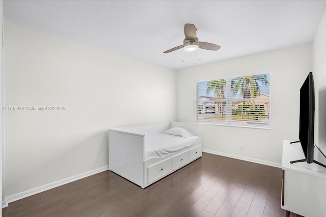 unfurnished bedroom with a ceiling fan, baseboards, and wood finished floors