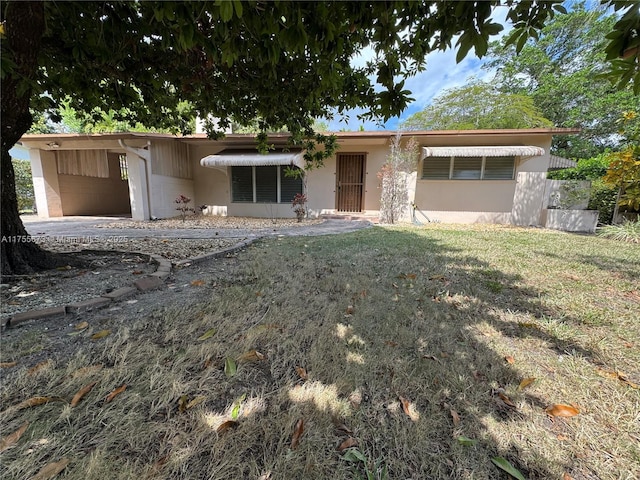 ranch-style house featuring a front lawn and stucco siding