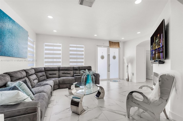 living room with marble finish floor, visible vents, arched walkways, and recessed lighting