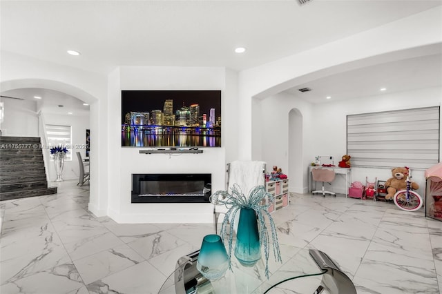 living room featuring baseboards, marble finish floor, arched walkways, and recessed lighting