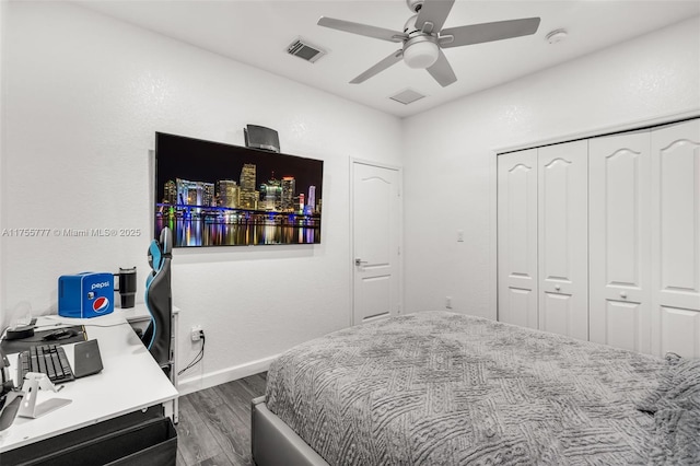 bedroom with baseboards, visible vents, a ceiling fan, dark wood-type flooring, and a closet