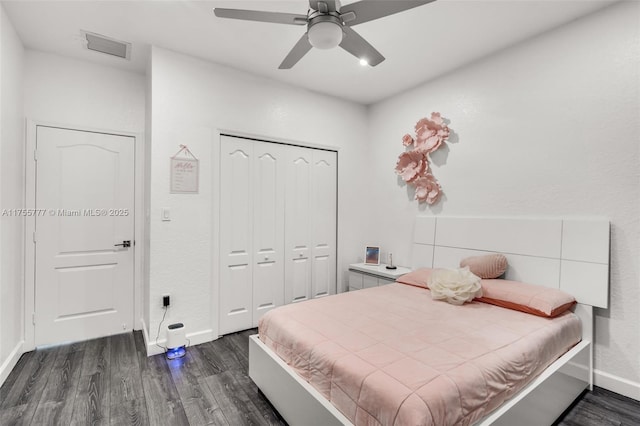 bedroom featuring ceiling fan, visible vents, baseboards, a closet, and dark wood finished floors