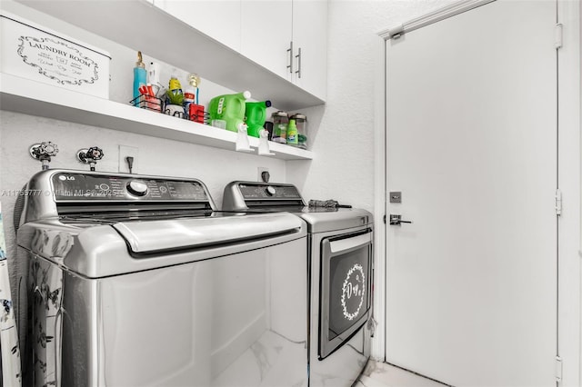 laundry room with marble finish floor, separate washer and dryer, and cabinet space