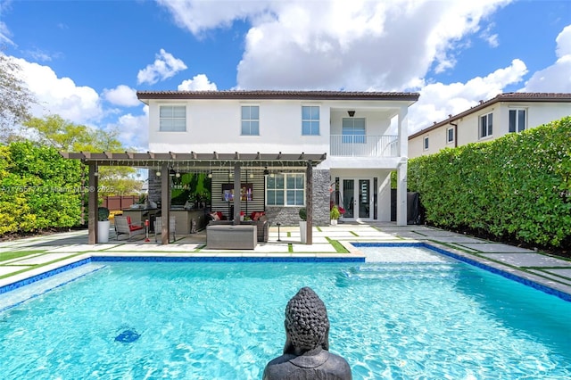 back of house featuring french doors, a patio area, a balcony, a pergola, and an outdoor pool