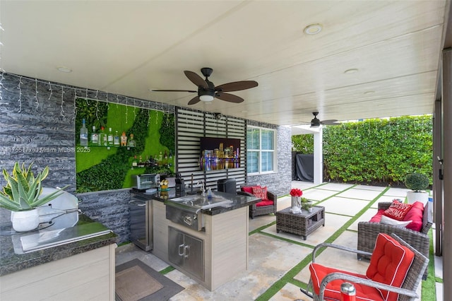 view of patio with an outdoor hangout area, ceiling fan, exterior kitchen, and a sink