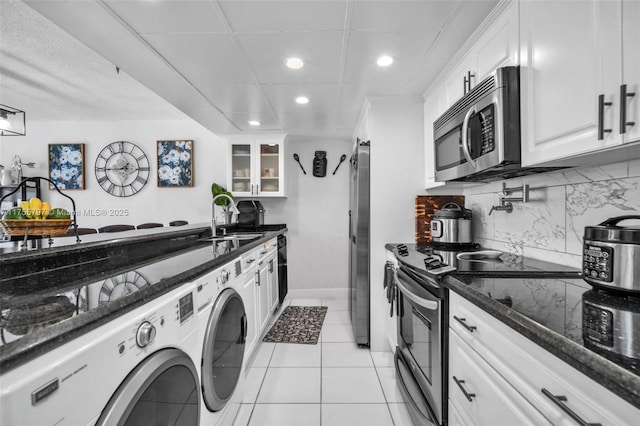 kitchen with backsplash, appliances with stainless steel finishes, white cabinets, and a sink