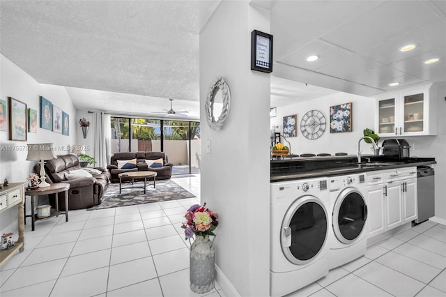 laundry room with light tile patterned floors, laundry area, a sink, and washing machine and dryer