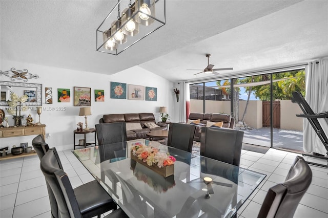 tiled dining space with lofted ceiling, ceiling fan, and a textured ceiling