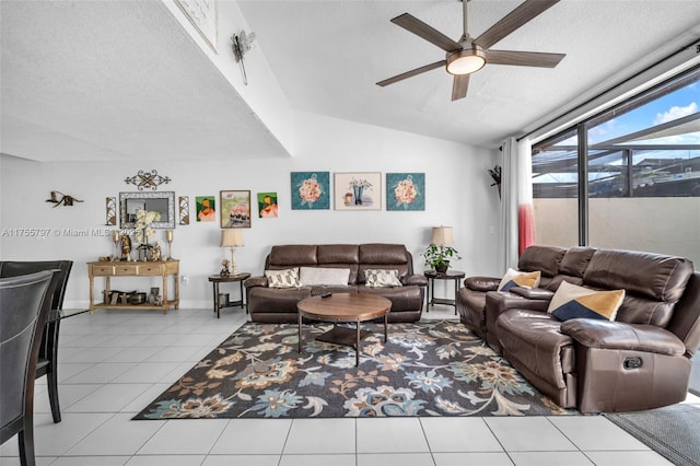 living room with a textured ceiling, tile patterned flooring, a ceiling fan, baseboards, and vaulted ceiling