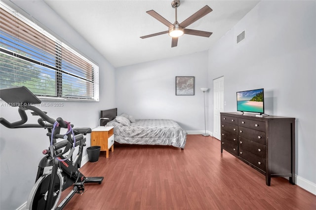 bedroom featuring lofted ceiling, visible vents, a ceiling fan, wood finished floors, and baseboards