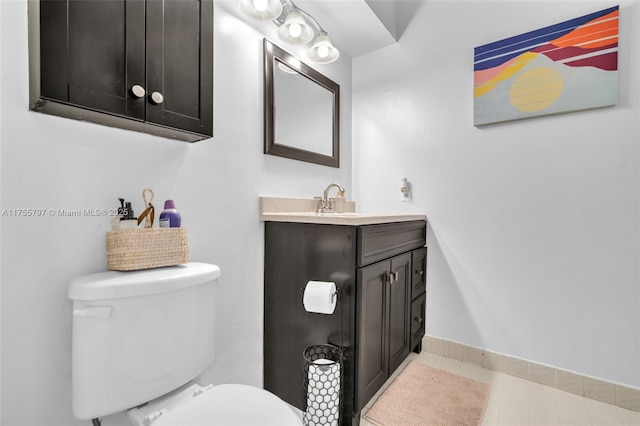 bathroom featuring tile patterned flooring, baseboards, vanity, and toilet