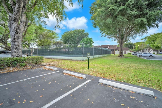 exterior space with a tennis court and fence