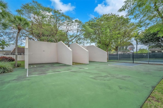 exterior space featuring community basketball court and fence