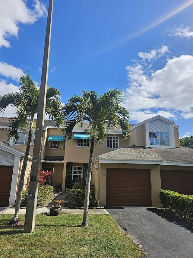 multi unit property featuring aphalt driveway, an attached garage, and stucco siding