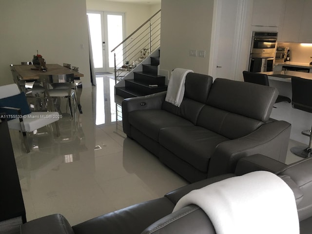 living area featuring stairs, french doors, and light tile patterned flooring