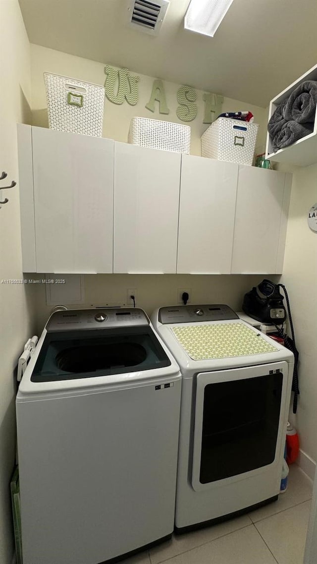 washroom with cabinet space, light tile patterned floors, visible vents, and independent washer and dryer