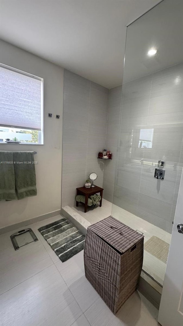 bathroom featuring tile patterned flooring and tiled shower